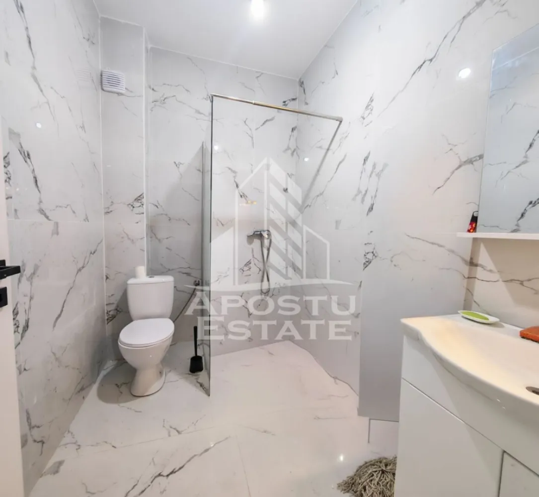 Apartament nou de vanzare, 2 camere, bucatarie inchisa, parter, Giroc - Apostu Estate va ofera spre vanzare un apartament nou, cu 2 camere, decomandat, cu bucatarie inchisa, situat la etajul 3 al unui imobil intabulat in anul 2025, in Timis, Giroc, zona Calea Urseni. Aproximativ 1 km distanta fata de Zone Cafe 2 si Mega Image Calea Urseni Timisoara. Acces facil la centura ocolitoare a orasului. Doar 300 m fata de prima statie a mijloacelor de transport in comun.

Imobil realizat din caramida Porotherm de 30 cm pe exterior, 25 cm zidurile pe interior si 11.5 zidurile de compartimentare la bai.
Izolatie de 10 cm EPS 80.
Acoperis din tigla.

Loc de parcare propriu inscris in cartea funciara.
Patru apartamente pe etaj. 
Regim de inaltime: P + 2 + M. 
Acoperis din tigla. 
Tamplarie PVC, geamuri tripan.

Confortul termic se realizeaza cu ajutorul centralei proprii pe gaz, incalzire in pardoseala.

Apartamentul dispune de 53 mpu, plus un balcon de aproximativ 5 - 6 mp. 
Compartimentat astfel:
- hol de acces generos
- bucatarie inchisa, 8 mp
- living, 18.5 mp
- dormitor, 14 mp
- baie cu dus, rigola si toaleta suspendata cu rezervor incorporat, 5 mp
- balcon deschis 

Agentia imobiliara Apostu Estate va ofera consultanta bancara gratuita prin intermediul colaboratorilor nostri pentru alegerea celui mai potrivit tip de credit, astfel incat tu sa devi noul proprietar al acestui apartament.

Va asteptam cu drag la o vizionare!