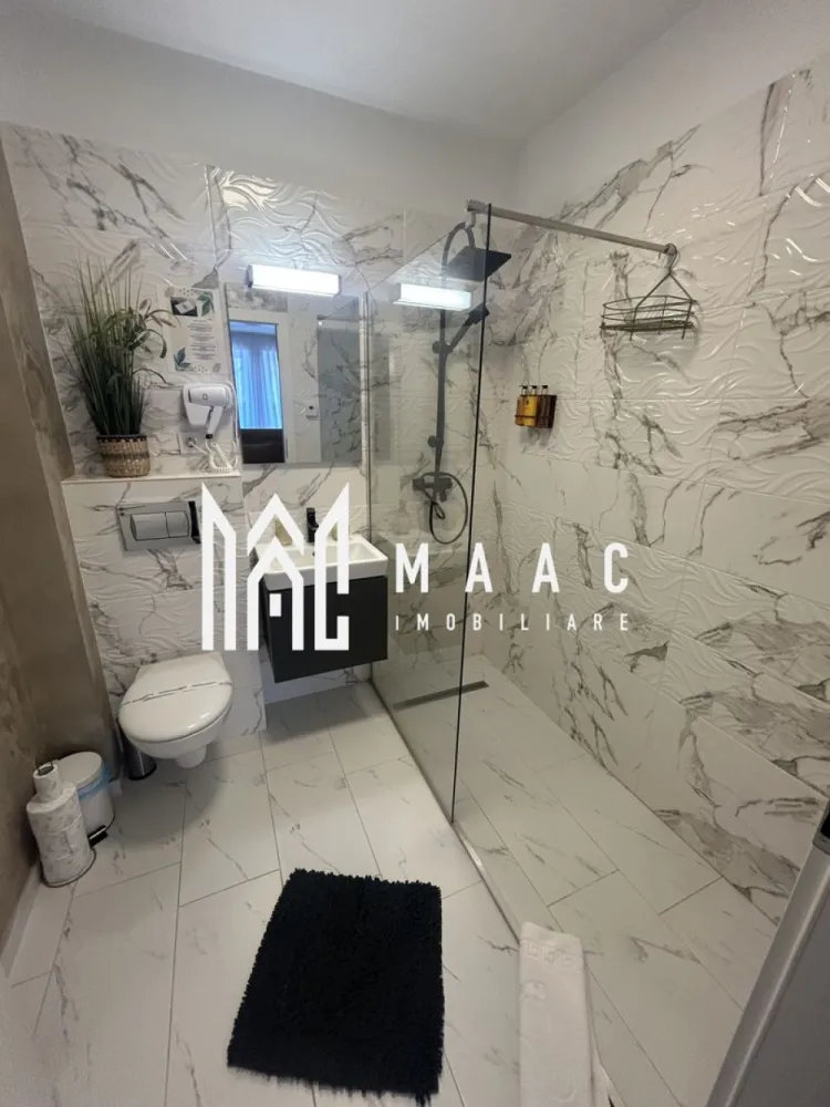 Apartament de lux 2 camere I Henri Coanda I Parcare I Vedere Panoramica - MAAC Imobiliare propune spre vânzare un apartament modern cu 2 camere, situat în cartierul rezidențial Henri Coandă din Sibiu, o zonă în plină dezvoltare, apreciată pentru liniște și accesibilitate. Proprietatea este amenajată la standarde premium, fiind gândită pentru a oferi confort, funcționalitate și un stil de viață modern. Apartamentul dispune de încălzire în pardoseală pentru un confort termic optim în sezonul rece, precum și de aer condiționat, ideal pentru zilele călduroase de vară. Locuința se vinde complet mobilată și utilată, fiind pregătită pentru mutare imediată sau pentru introducerea în circuitul de închiriere. Bucătăria este complet echipată, dotată cu plită electrică, frigider și electrocasnicele necesare utilizării zilnice. În plus, fiecare cameră este dotată cu televizor, iar mobilierul modern, de calitate superioară, completează designul elegant al apartamentului. Această proprietate reprezintă o oportunitate excelentă de investiție, fiind ideală atât pentru regim hotelier, cât și pentru închiriere pe termen lung sau locuință personală. Avantaje: încălzire în pardoseală aer condiționat bucătărie complet utilată televizoare în fiecare cameră mobilier modern, de calitate superioară loc de parcare inclus Bonus: Primele apartamente vândute vor beneficia de spațiu de depozitare la subsol, ideal pentru depozitarea obiectelor personale sau sezoniere. Pentru mai multe informații și programări la vizionare, vă rugăm să menționați ID anunț: CP2956227 }}