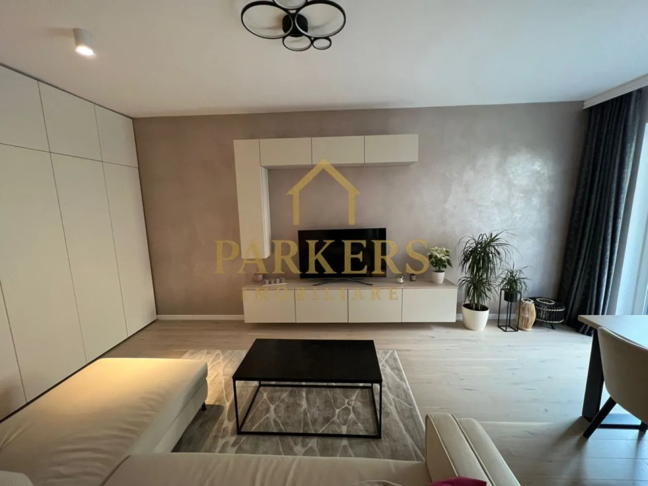 Apartament modern 2 camere și grădină proprie, semicentral-Record Park - Parkers Imobiliare vă propune spre vânzare un apartament deosebit cu 2 camere, situat în incinta ansamblului rezidențial Record Park, una dintre cele mai apreciate și căutate zone semicentrale din Cluj-Napoca, cu acces rapid către centrul orașului și principalele puncte de interes. Apartamentul impresionează prin designul interior realizat cu ajutorul unui designer, finisajele atent alese și compartimentarea eficientă, care oferă un spațiu modern, confortabil și bine organizat. Detalii proprietate: - Suprafață utilă: 57 mp - Grădină proprie: 77 mp - Compartimentare: living cu bucătărie, dormitor matrimonial, hol, baie - Design interior realizat cu ajutorul unui designer - Spații de depozitare integrate inteligent Unul dintre principalele atuuri ale proprietății este grădina proprie de 77 mp, un spațiu generos și rar întâlnit în această zonă. Aceasta include o terasă amenajată cu deck din lemn, ideală pentru relaxare, socializare sau momente petrecute în aer liber. Parcare: - loc de parcare subteran disponibil - spațiu suplimentar de depozitare tip dulap metalic cu închidere jaluzea - preț: 25.000 euro - achiziția parcării nu este obligatorie Avantaje ale zonei: - ansamblu rezidențial modern și apreciat - aproximativ 1 km de Piața Mihai Viteazu - acces rapid către centru, universități și mijloace de transport -apropiere de magazine, restaurante și servicii Dacă îți dorești confortul unui apartament modern, aproape de inima orașului, dar cu intimitatea și relaxarea oferite de o grădină proprie, această proprietate poate fi alegerea ideală. }}