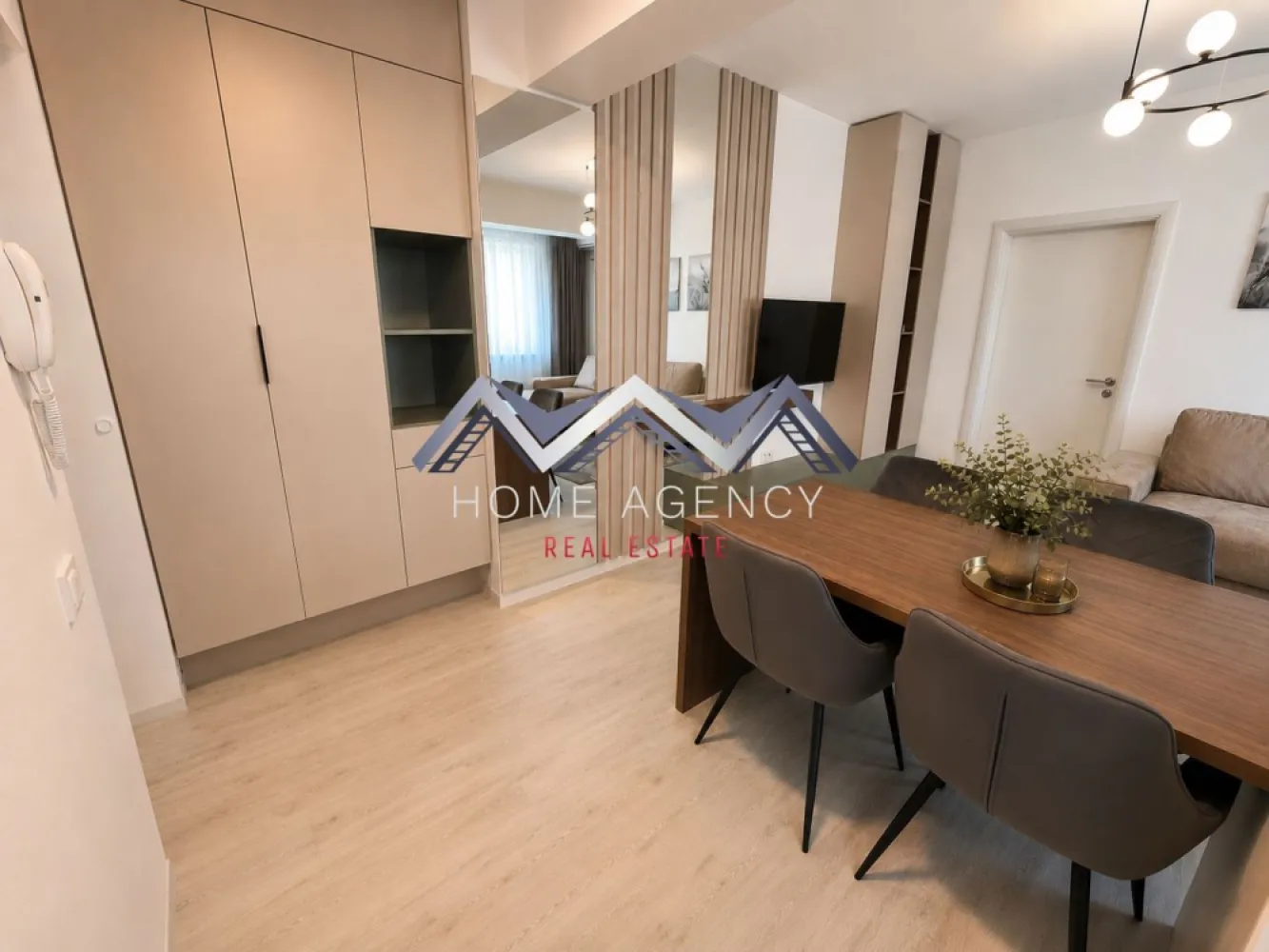 Apartament 2 camere | parcare subterană | Otopeni central - Vă propunem spre închiriere un apartament cu 2 camere, aflat la prima închiriere, care îmbină designul contemporan, finisajele atent alese și confortul unei locuințe amenajate cu grijă pentru viitorii săi locatari. Situat într-o zonă centrală din Otopeni, apartamentul oferă acces rapid către DN1 și principalele puncte de interes din Otopeni și Nordul Bucureștiului, fiind alegerea ideală pentru cei care își doresc un stil de viață modern, într-o locație excelent conectată.

Încă de la intrare, apartamentul se remarcă prin atmosfera luminoasă și aerisită, mobilierul realizat pe comandă și paleta cromatică neutră, care pune în valoare fiecare spațiu. Compartimentarea este eficientă și bine gândită, oferind un echilibru firesc între funcționalitate și confort.

Zona de zi reunește livingul și diningul într-un ambient primitor, ideal atât pentru momentele de relaxare, cât și pentru întâlnirile cu familia sau prietenii. Bucătăria, complet mobilată și utilată cu electrocasnice încorporate, completează armonios zona de zi și oferă tot confortul necesar utilizării de zi cu zi.

Dormitorul a fost amenajat într-un stil minimalist și elegant, oferind un ambient liniștit și relaxant, în timp ce baia completează locuința prin finisajele moderne și atenția acordată fiecărui detaliu.

Locuința beneficiază de încălzire în pardoseală, centrală termică proprie, aer condiționat, mobilier realizat pe comandă și dotări atent alese, de la electrocasnicele încorporate și mașina de spălat vase din bucătărie, până la mașina de spălat rufe cu funcție de uscător, amplasată în baie.

Vă invităm cu drag la o vizionare pentru a descoperi toate avantajele acestui apartament.