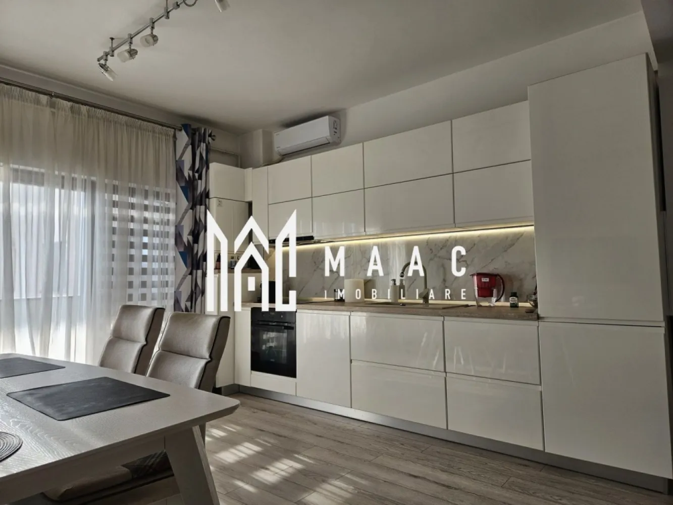 Apartament 3 camere |Dem. Radulescu| 94,5mp |2 locuri parcare - MAAC IMOBILIARE vă propune spre vânzare un apartament spațios și elegant situat pe Bulevardul Dem Rădulescu, în Râmnicu Vâlcea, în blocul în care se află restaurantul La Trattoria. Apartamentul este amplasat la etajul 4 din 7, într-un imobil dotat cu lift generos, și beneficiază de o poziționare excelentă, cu vedere pe spate, spre răsărit, oferind liniște, lumină naturală și o priveliște plăcută, fiind ferit de zgomotul bulevardului. Locuința dispune de o suprafață totală de aproximativ 94,5 mp, dintre care 80 mp suprafață utilă și terasă de 14,5 mp, iar înălțimea tavanului de 2,85 m oferă un plus de spațiu și eleganță. Ferestrele mari din living, de sus până jos, permit pătrunderea abundentă a luminii naturale și creează o atmosferă modernă și aerisită. Compartimentare: Hol: 14,6 mp Living + bucătărie open-space: 27,5 mp Dormitor: 16,5 mp Dressing / cameră multifuncțională: 14,4 mp Baie: 6,88 mp Terasă: 14,5 mp Dotări și finisaje premium: Baie modernă cu mobilier Delta Studio din MDF vopsit lucios Vas WC și bideu suspendate Baterii Ideal Standard Sistem de duș Grohe cu baterie cu termostat Bucătărie complet utilată: Mobilier Lucky Man din MDF vopsit lucios, echipată cu electrocasnice incorporate: cuptor și plită electrică Zanussi hotă frigider Electrolux mașină de spălat vase Alte dotări: Aer condiționat Gree cu Wi-Fi Perdele și draperii Maria Design Corpuri de iluminat LED Masă cu 6 scaune Tâmplărie Salamander Ușă metalică Megadoor Centrală termică Immergas Apartamentul este foarte bine izolat și călduros pe timpul iernii, ceea ce se reflectă în costuri reduse la întreținere și facturi mici la gaz. Un avantaj important al proprietății îl reprezintă cele 2 locuri de parcare private, fiecare având act de proprietate. Această locuință este ideală pentru cei care își doresc confort, spațiu și o locație premium într-una dintre cele mai căutate zone ale orașului. Pentru mai multe informații sau pentru programarea unei vizionări, echipa MAAC IMOBILIARE vă stă la dispoziție. CP2962530 }}