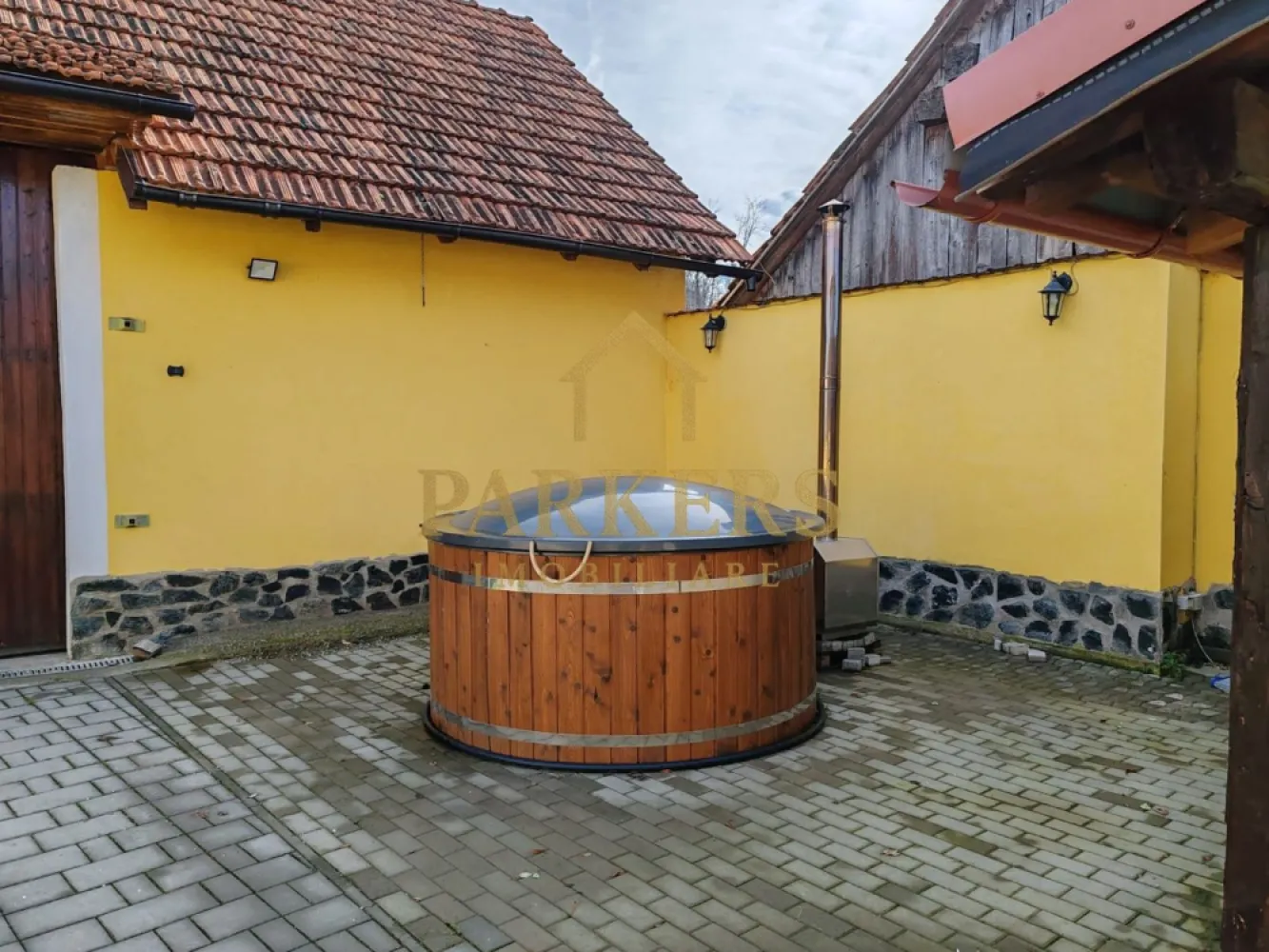 Reședință exclusivistă – 600 mp utili, facilități complete - Proprietate de excepție – eleganță, spațiu și funcționalitate la standarde înalte Parkers Imobiliare vă propune spre vânzare o reședință impresionantă, concepută pentru confort, intimitate și un stil de viață complet, situată într-un cadru sigur și bine organizat. Imobilul este dispus pe două niveluri, cu pivniță interioară, oferind o suprafață generoasă de aproximativ 600 mp utili, excelent compartimentați. Zona de acces întâmpină printr-un spațiu de tip vestiar, cu intrare către pivniță și camera tehnică, echipată cu două sisteme de încălzire: centrală pe gaz de 35 kW și centrală pe lemne de 80 kW – o soluție eficientă și sigură pentru orice sezon. Parterul este dedicat vieții de zi, cu un living amplu, luminos, care face legătura naturală între zonele funcționale ale casei. Bucătăria este complet utilată și dotată cu cuptor pe lemne, având acces către cămara și spălătorie, iar spațiul este completat de băi și zone de depozitare bine gândite. Tot la acest nivel se află și zona de noapte, compusă din holuri, două dormitoare și baie, oferind intimitate și confort. Etajul adaugă valoare printr-o compartimentare practică și versatilă: dormitoare spațioase, birou, dressing / depozit pentru haine și accesorii, baie, spații de depozitare și un balcon comunicant, ideal pentru momente de relaxare. Proprietatea se vinde complet mobilată și utilată, cu mobilier și accesorii atent alese, gata pentru mutare imediată. Exteriorul completează perfect experiența acestei reședințe: curte amenajată și împrejmuită garaj cu grup sanitar propriu foisor cu apă terasă generoasă piscină sală de fitness șemineu și zonă de grătar grădină bine întreținută proprietate sigură și privată Această casă nu este doar un imobil, ci un concept de locuire premium, ideal pentru o familie care își dorește spațiu, confort și independență, fără compromisuri. }}