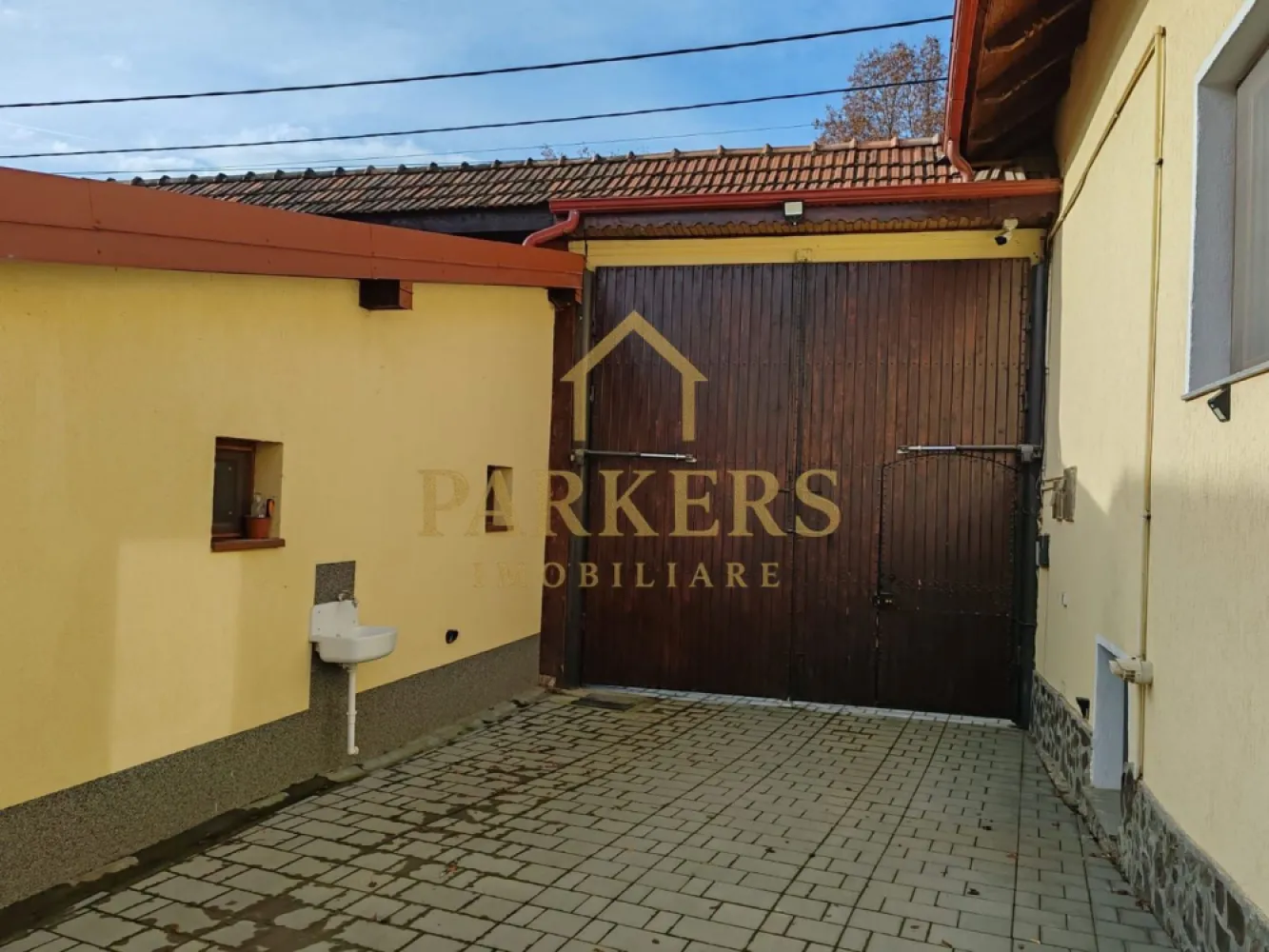 Reședință exclusivistă – 600 mp utili, facilități complete - Proprietate de excepție – eleganță, spațiu și funcționalitate la standarde înalte Parkers Imobiliare vă propune spre vânzare o reședință impresionantă, concepută pentru confort, intimitate și un stil de viață complet, situată într-un cadru sigur și bine organizat. Imobilul este dispus pe două niveluri, cu pivniță interioară, oferind o suprafață generoasă de aproximativ 600 mp utili, excelent compartimentați. Zona de acces întâmpină printr-un spațiu de tip vestiar, cu intrare către pivniță și camera tehnică, echipată cu două sisteme de încălzire: centrală pe gaz de 35 kW și centrală pe lemne de 80 kW – o soluție eficientă și sigură pentru orice sezon. Parterul este dedicat vieții de zi, cu un living amplu, luminos, care face legătura naturală între zonele funcționale ale casei. Bucătăria este complet utilată și dotată cu cuptor pe lemne, având acces către cămara și spălătorie, iar spațiul este completat de băi și zone de depozitare bine gândite. Tot la acest nivel se află și zona de noapte, compusă din holuri, două dormitoare și baie, oferind intimitate și confort. Etajul adaugă valoare printr-o compartimentare practică și versatilă: dormitoare spațioase, birou, dressing / depozit pentru haine și accesorii, baie, spații de depozitare și un balcon comunicant, ideal pentru momente de relaxare. Proprietatea se vinde complet mobilată și utilată, cu mobilier și accesorii atent alese, gata pentru mutare imediată. Exteriorul completează perfect experiența acestei reședințe: curte amenajată și împrejmuită garaj cu grup sanitar propriu foisor cu apă terasă generoasă piscină sală de fitness șemineu și zonă de grătar grădină bine întreținută proprietate sigură și privată Această casă nu este doar un imobil, ci un concept de locuire premium, ideal pentru o familie care își dorește spațiu, confort și independență, fără compromisuri. }}