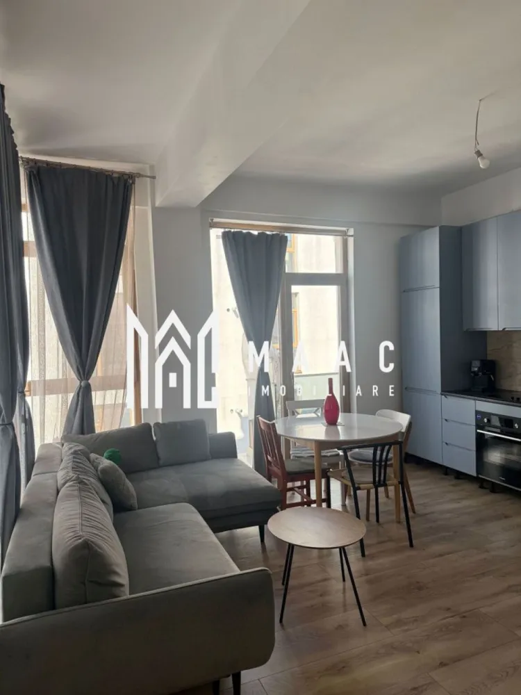 Apartament 3 Camere I Etaj 1 I 63 MPU I Terasa I O. Goga - MAAC Imobiliare vă propune spre vânzare un apartament modern cu 3 camere, decomandat, luminos și foarte bine compartimentat, situat într-o zonă excelentă – vis-a-vis de Shopping City Sibiu. Locuința impresionează prin spațiul generos, tavanele înalte și finisajele premium, fiind alegerea ideală pentru cei care își doresc confort, design modern și acces rapid la toate facilitățile orașului.Se vinde complet mobilat și utilat, fiind practic gata pentru mutare. Proprietatea a fost locuită doar ocazional, motiv pentru care se prezintă aproape ca nouă, necesitând doar câteva mici retușuri pentru finalizare. Compartimentare: living spațios cu bucătărie open-space două dormitoare confortabile baie modernă terasă balcon Dotări și finisaje premium: ✔ încălzire în pardoseală pentru confort termic superior ✔ centrală termică în condensare, foarte economică, cu termostate automatizate pentru fiecare încăpere ✔ aer condiționat cu funcție de răcire și încălzire ✔ uși înalte, de calitate germană, cu izolare fonică ridicată ✔ parchet rezistent la apă, compatibil cu încălzirea în pardoseală, cu folie izolatoare premium (transfer termic excelent) ✔ bucătărie realizată la comandă, complet echipată: frigider, mașină de spălat vase, cuptor încorporat, plită electrică + gaz și espressor ✔ masă extensibilă robustă pentru până la 10 persoane, cu scaune moderne ✔ canapea designer, de calitate superioară ✔ paturi de 180 cm cu saltele premium ✔ șifoniere moderne, înalte și încăpătoare ✔ mașină de spălat rufe cu uscător ✔ duș walk-in la nivelul pardoselii, realizat pe comandă din sticlă cu strat antibacterian ✔ blat de marmură pentru baie, adus din Italia și finisat la comandă ✔ Smart TV 65” 4K, 144Hz Loc de parcare. Apartamentul este situat într-un cartier modern, în plină dezvoltare, cu grad de ocupare în continuă creștere și acces rapid către magazine, restaurante, transport și zone comerciale, toate la câteva minute de mers pe jos. Pentru mai multe detalii si programarea unei vizionari vă rugăm să specificați că ați văzut anunțul cu ID: CP2969270. }}