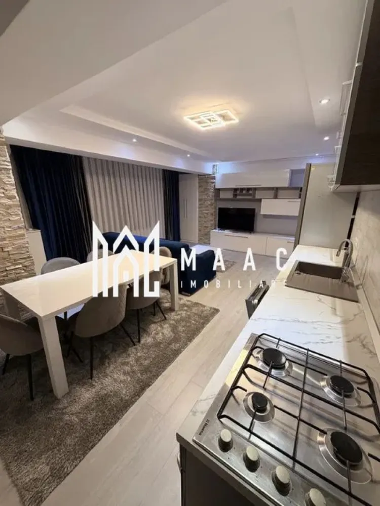 Apartament 2 camere | Șelimbăr – Doamna Stanca | Lângă Kaufland - MAAC Imobiliare vă propune spre închiriere un apartament modern cu 2 camere, situat în Șelimbăr, pe strada Doamna Stanca, într-un complex rezidențial apreciat, aflat în imediata apropiere a Kaufland Șelimbăr și la doar câteva minute de Shopping City Sibiu. Locuința are o suprafață utilă de 58 mp (exclus balcon) și este compartimentată eficient, oferind un spațiu bine organizat: living open space cu bucătărie complet echipată dormitor spațios baie modernă, dotată cu duș walk-in Apartamentul este complet mobilat și utilat cu mobilier modern și electrocasnice de calitate, fiind pregătit pentru mutare imediată. Printre dotări se numără: mașină de spălat rufe cu uscător (LG 2 în 1) mașină de spălat vase frigider, aragaz și cuptor aer condiționat televizoare în fiecare cameră finisaje premium (parchet, gresie, faianță tip mozaic) Imobilul dispune de locuri de parcare în regim „primul venit – primul servit”, însă locul de parcare nu este inclus în prețul chiriei. Condiții de închiriere: nu se acceptă animale de companie disponibilitate imediata. Pentru mai multe detalii și programarea unei vizionări, vă invităm să ne contactați, menționând ID-ul ofertei:CP2978046 }}