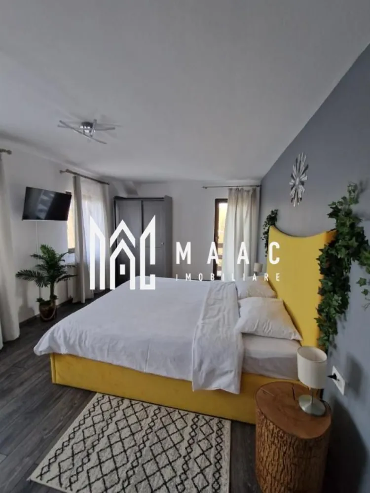 Pensiune Turistica | 360MPU | Porumbacu de Sus - MAAC Imobiliare vă propune spre vânzare o pensiune / casă de vacanță complet funcțională, situată în Porumbacu de Sus, una dintre cele mai apreciate zone turistice din județul Sibiu. Cu o activitate solidă de peste 4 ani și un flux constant de turiști, proprietatea reprezintă o afacere matură, stabilă și pregătită pentru preluare imediată. Construită în 2021 și menținută impecabil, pensiunea oferă 360 mp utili, inteligent compartimentați pentru confort și funcționalitate. Clădirea principală este dispusă pe parter, etaj și pod mansardat, beneficiind de 5 unități de cazare, fiecare cu baie proprie și balcon -un apartament, o cameră triplă și trei camere duble. Spațiile sunt luminoase, curate și gândite pentru a răspunde nevoilor fiecărui oaspete. La acestea se adaugă un living generos, o bucătărie complet utilată, șase dormitoare, șase băi. Regasim și o terasă de aproximativ 20 mp — locul ideal pentru relaxare și socializare. În exterior este amenajată și o bucătărie de vară cu foișor și zonă de barbecue, spațiu preferat de turiști în sezonul cald. Din punct de vedere tehnic, proprietatea dispune de încălzire centrală pe peleți, izolație exterioară de 10 cm, acoperiș Bilka, alimentare cu apă de la rețea plus fântână proprie, contor trifazic Totul este pregătit pentru continuarea activității turistice fără investiții imediate. Proprietatea se află pe un teren de 1.000 mp, dintre care aproximativ 900 mp reprezintă curte liberă — un spațiu generos, ideal pentru amenajarea unor facilități suplimentare precum saună, ciubăr, zone de relaxare sau noi unități de cazare. Pe lângă clădirea principală, în partea din spate a terenului se află o cabană secundară din lemn, de aproximativ 50 mp, P+M, locuibilă, care necesită renovare, dar oferă un potențial foarte bun pentru extinderea capacității sau pentru proiecte independente de cazare. Curtea dispune de 6–7 locuri de parcare, acces facil și un cadru natural liniștit, apreciat de turiști pe tot parcursul anului. Datorită apropierii de Transfăgărășan, Castelul de Lut Valea Zânelor, Sibiu și numeroase trasee montane, vizibilitatea și cererea sunt constante. Recomandată pentru investitori în turism, familii ce caută o afacere în exploatare sau proiecte de extindere tip mini-complex turistic, această proprietate oferă siguranță, potențial și un cadru natural deosebit. Pentru mai multe detalii și programarea unei vizionări, contactați agenția MAAC Imobiliare și specificați ID-ul anunțului: CP2819284. }}