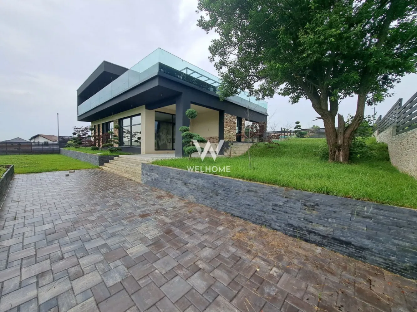 Vilă modernă premium cu piscină interioară, teren 1200 mp și panoramă - Descoperă o proprietate cu adevărat specială, concepută pentru cei care își doresc confort, intimitate și un stil de viață premium, într-o zonă liniștită, cu panoramă superbă asupra dealurilor din Cisnădie si spre Cisnadioara, la doar 15 minute de centrul Sibiului. Această casă individuală, cu design modern ofera spații generoase și un flow perfect între interior și exterior, ideal pentru viața de familie sau chiar pentru un concept exclusivist de business (boutique retreat / centru wellness). Proprietatea dispune de 240 mp utili și este amplasată pe un teren generos de 1200 mp, care oferă intimitate, spațiu verde și multiple posibilități de amenajare. Un element rar întâlnit este piscina interioară de aproximativ 50 mp, un adevărat lux personal, care transformă locuința într-un spațiu de relaxare și wellness în orice sezon. Zona de zi impresionează printr-un living amplu open-space cu bucătăria și zona de dining, gândite pentru conexiune și socializare, cu ieșire directă către terasa acoperită destinată zonei de barbeque. Un alt avantaj major este garajul cu acces direct în holul casei, oferind confort și funcționalitate în viața de zi cu zi. Compartimentare: Parter: • hol de acces • baie • garaj cu acces direct în casă • cameră tehnică / lavanderie • spațiu de depozitare • piscină interioară (aprox. 50 mp) • living generos cu dining și bucătărie open-space • terasă acoperită pentru barbeque Etaj: • hol • 4 dormitoare luminoase • 2 băi (un dormitor cu baie proprie) • terasă circulabilă cu acces din 3 camere – ideală pentru jacuzzi sau zonă lounge • balcon cu priveliște frumoasă către dealuri Terenul de 1200 mp este terasat și oferă: • spațiu generos pentru parcarea mai multor mașini • zone pentru relaxare și petrecerea timpului cu familia și prietenii • vegetație tânără și posibilitatea de amenajare personalizată după propriul stil de viață. Această proprietate este alegerea perfectă pentru cei care își doresc liniște, natură, spațiu și confort modern, într-o casă spectaculoasă aproape de oraș. PRET: 550 000 EUR + 21 % TVA Telefon: 0756 094 405 }}