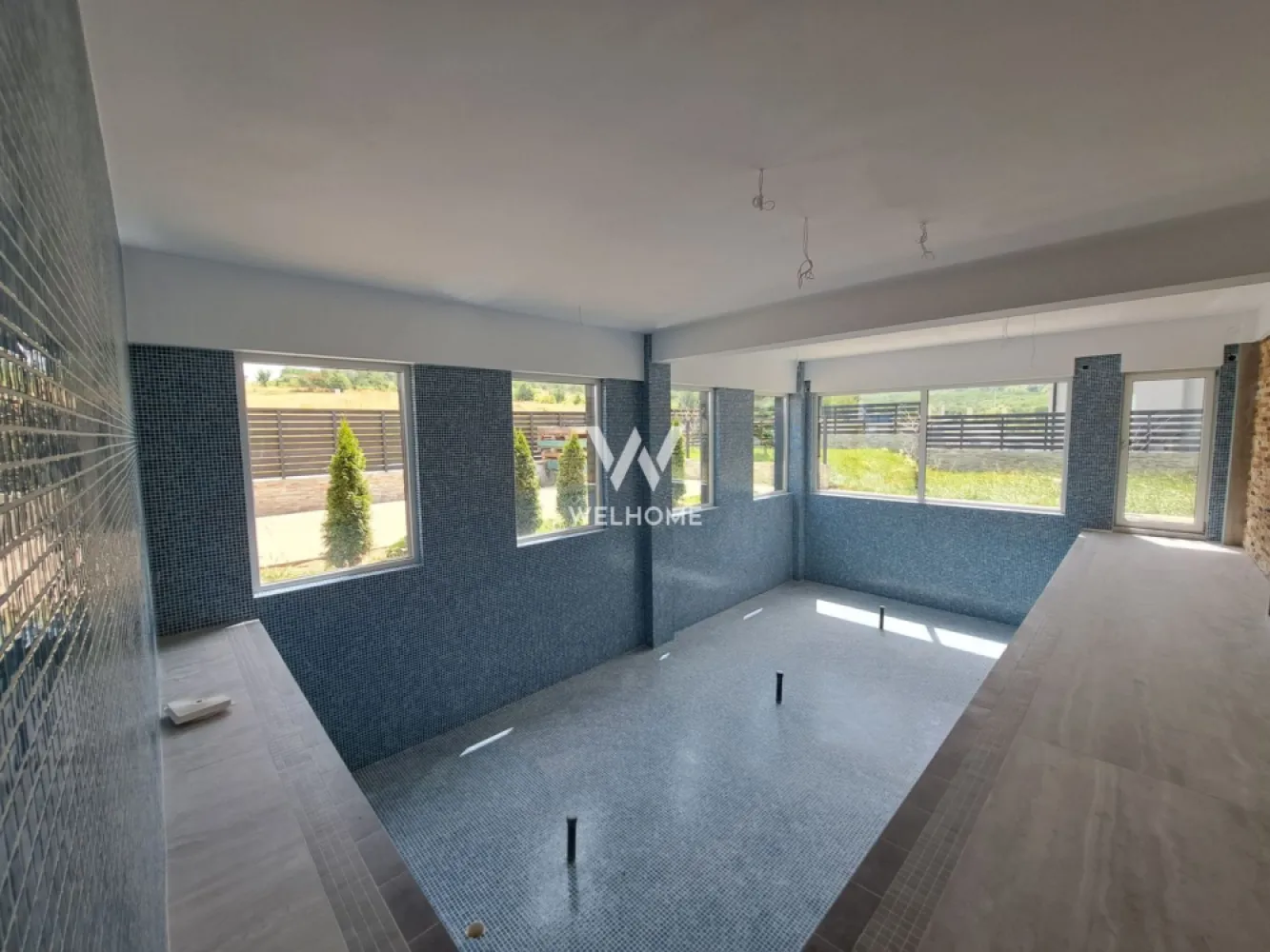 Vilă modernă premium cu piscină interioară, teren 1200 mp și panoramă - Descoperă o proprietate cu adevărat specială, concepută pentru cei care își doresc confort, intimitate și un stil de viață premium, într-o zonă liniștită, cu panoramă superbă asupra dealurilor din Cisnădie si spre Cisnadioara, la doar 15 minute de centrul Sibiului. Această casă individuală, cu design modern ofera spații generoase și un flow perfect între interior și exterior, ideal pentru viața de familie sau chiar pentru un concept exclusivist de business (boutique retreat / centru wellness). Proprietatea dispune de 240 mp utili și este amplasată pe un teren generos de 1200 mp, care oferă intimitate, spațiu verde și multiple posibilități de amenajare. Un element rar întâlnit este piscina interioară de aproximativ 50 mp, un adevărat lux personal, care transformă locuința într-un spațiu de relaxare și wellness în orice sezon. Zona de zi impresionează printr-un living amplu open-space cu bucătăria și zona de dining, gândite pentru conexiune și socializare, cu ieșire directă către terasa acoperită destinată zonei de barbeque. Un alt avantaj major este garajul cu acces direct în holul casei, oferind confort și funcționalitate în viața de zi cu zi. Compartimentare: Parter: • hol de acces • baie • garaj cu acces direct în casă • cameră tehnică / lavanderie • spațiu de depozitare • piscină interioară (aprox. 50 mp) • living generos cu dining și bucătărie open-space • terasă acoperită pentru barbeque Etaj: • hol • 4 dormitoare luminoase • 2 băi (un dormitor cu baie proprie) • terasă circulabilă cu acces din 3 camere – ideală pentru jacuzzi sau zonă lounge • balcon cu priveliște frumoasă către dealuri Terenul de 1200 mp este terasat și oferă: • spațiu generos pentru parcarea mai multor mașini • zone pentru relaxare și petrecerea timpului cu familia și prietenii • vegetație tânără și posibilitatea de amenajare personalizată după propriul stil de viață. Această proprietate este alegerea perfectă pentru cei care își doresc liniște, natură, spațiu și confort modern, într-o casă spectaculoasă aproape de oraș. PRET: 550 000 EUR + 21 % TVA Telefon: 0756 094 405 }}