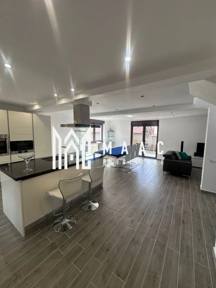 Proprietate individuala în Tălmaciu | Încălzire în pardoseală | Dotări de top - MAAC Imobiliare vă propune spre vânzare: Casă modernă, complet mobilată și utilată Vă prezentăm o proprietate deosebită, ideală pentru cei care își doresc un stil de viață confortabil, într-o locuință modernă, complet echipată și atent finisată. Casa este amplasată pe colț și beneficiază de două intrări auto, oferind acces facil și un plus de versatilitate. Imobilul are o suprafață utilă de 170 mp și este compartimentat eficient pe două niveluri: Parter: living generos open-space cu bucătărie baie de serviciu Etaj: 3 dormitoare spațioase (dintre care 2 cu balcon) baie mare, complet echipată cu cadă, duș și bideu Confortul termic este asigurat prin încălzire în pardoseală, susținută de un sistem dual de încălzire (centrală pe gaz și centrală pe lemne), completat de un puffer de 2000 litri, pentru eficiență și autonomie ridicată. Proprietatea impresionează prin dotările moderne și calitatea finisajelor: sanitare premium Villeroy & Boch bucătărie complet echipată, cu insulă și electrocasnice moderne (plită pe inducție, hotă, cuptor, cuptor cu microunde, mașină de spălat vase, frigider, frigider de vinuri, aparat de cafea) mașină de spălat rufe și uscător sistem de supraveghere video rulouri exterioare electrice, acționate prin telecomandă videointerfon Accesul în curte se face prin două porți: o poartă automată, cu telecomandă o a doua poartă pregătită pentru automatizare (instalație deja realizată) În curte se regăsește și un spațiu auxiliar tip atelier, ce poate fi utilizat ca zonă de depozitare sau bucătărie de vară. Casa este complet mobilată modern, oferind un ambient elegant și funcțional, fiind pregătită pentru mutare imediată, fără investiții suplimentare. Această proprietate este alegerea ideală pentru o familie care caută liniște, spațiu și un standard ridicat de confort, într-o locuință cu adevărat completă. Pentru detalii suplimentare, consultanță sau programarea unei vizionări, va rugăm să ne contactati specificand ID: CP3019905 }}