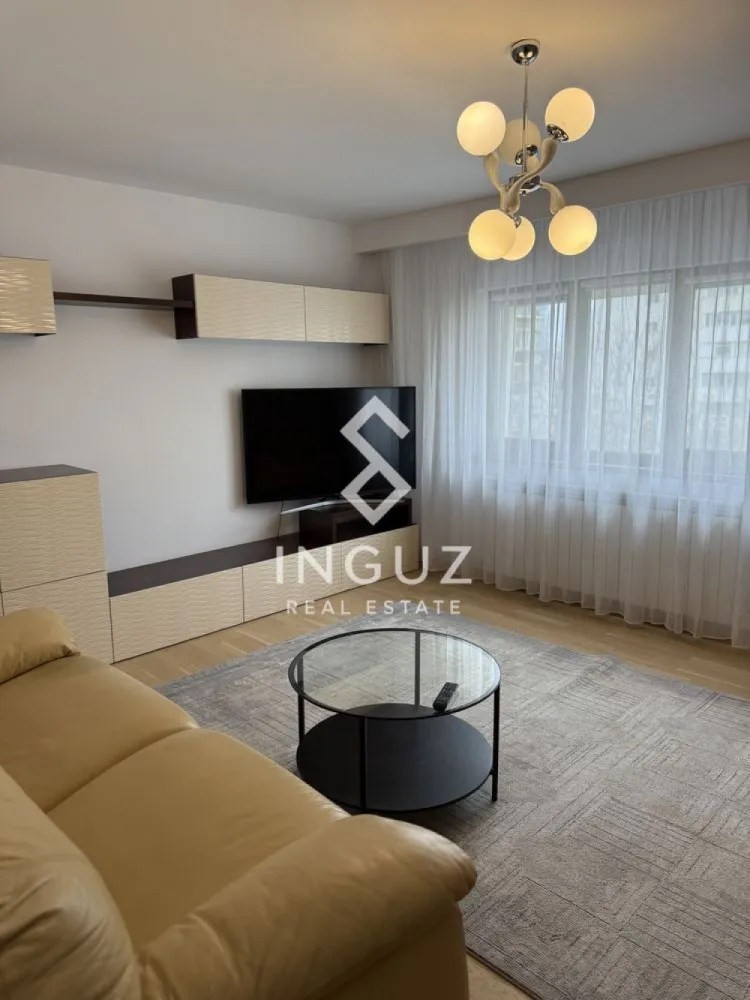 Apartament 3 camere de închiriat – Nerva Traian / Anastasie Panu - Apartament 3 camere de închiriat – Nerva Traian / Anastasie Panu Preț: 700 EUR / lună Suprafață: 75 mp (aprox. 9 €/mp) Locație: București – zona Nerva Traian Specificații: Tip proprietate: Apartament Tip tranzacție: Închiriere Număr camere: 3 Compartimentare: Decomandat Etaj: 4 Suprafață utilă: 75 mp Grupuri sanitare: 2 Descriere: Inguz Real Estate vă propune spre închiriere un apartament spațios cu 3 camere, decomandat, situat pe strada Anastasie Panu nr. 20, într-o zonă urbană foarte bine conectată. Apartamentul are o suprafață de aproximativ 75 mp și dispune de finisaje de calitate, pardoseli din lemn și feronerie premium, oferind un aspect modern și confortabil. Livingul beneficiază de lumină naturală generoasă, datorită ferestrelor mari cu vedere către stradă. Se închiriază complet mobilat și utilat, fiind pregătit pentru mutare imediată. De asemenea, proprietatea include loc de parcare ADP. Localizarea oferă acces rapid la mijloacele de transport în comun (autobuz și metrou), precum și la numeroase facilități: restaurante, cafenele, zone de relaxare, parcuri și instituții de învățământ. Mențiuni: – 2 grupuri sanitare – Nu se acceptă animale de companie }}