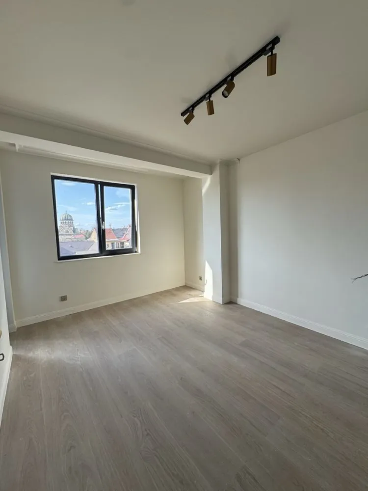 BRASADAS vinde ap 2 cam Central Loc de Parcare Bloc nou - Agentia Imobiliara BRASADAS vinde apartaent modern cu doua camere într-un bloc nou, construit după standarde moderne de siguranță și eficiență. Locuința este amplasată la etajul 4 din 5, oferind o priveliște plăcută asupra împrejurimilor și multă lumină naturală. Apartamentul are o suprafață utilă totală de 55 mp și este compartimentat eficient, astfel încât fiecare spațiu să fie valorificat la maximum. Zona de zi este concepută într-un concept open-space împreună cu bucătăria, creând un spațiu luminos și primitor, ideal pentru relaxare sau pentru petrecerea timpului cu familia și prietenii. Din living există acces direct către o terasă de aproximativ 5 mp, placată cu gresie, perfectă pentru momentele de relaxare în aer liber. Atât livingul, cât și dormitorul au acces direct pe această terasă, oferind lumină naturală și un spațiu exterior plăcut. Dormitorul este generos și dispune de o zonă dedicată de dressing, oferind spațiu suplimentar pentru depozitare. Baia este prevăzută cu geam pentru aerisire naturală și este complet utilată cu gresie, faianță, cadă și vas de toaletă. Apartamentul se predă complet finisat, fiind dotat cu ușă de acces metalică, ferestre termopan cu trei sticle pentru o izolare termică și fonică superioară, uși interioare din lemn și sistem de încălzire în pardoseală pentru un confort sporit. În zona bucătăriei sunt montate gresie și faianță, în living și dormitor este instalat parchet special pentru încălzirea în pardoseală, iar baia este complet finisată. De asemenea, locuința este echipată cu întrerupătoare, prize, corpuri de iluminat și este complet zugrăvită. Un avantaj important al acestui apartament este faptul că se vinde împreună cu un proiect personalizat de design interior, care te scapă de griji și îți oferă o viziune clară asupra amenajării, economisind timp și resurse în procesul de mobilare și decorare. Imobilul este construit pe fundație din beton armat, cu stâlpi de susținere din beton armat, iar pereții de compartimentare ai apartamentului sunt realizați din cărămidă și izolați corespunzător, completând structura solidă a clădirii cu elemente decorative moderne. Curtea blocului este complet împrejmuită, accesul fiind securizat printr-o poartă mecanizată. Zona exterioară este pavată, iar accesul în casa scării se face prin ușă termopan. Casa scării este finisată cu gresie ceramică, balustrada este metalică, iar clădirea este dotată cu lift, pentru un plus de confort. Apartamentul beneficiază și de un loc de parcare. Poziționarea este una deosebit de avantajoasă, imobilul fiind situat la câțiva pași de Kaufland, Media Galaxy, școli, grădinițe, stații de autobuz și taxi. De asemenea, la aproximativ 5 minute de mers pe jos se află Parcul Central al municipiului Satu Mare, un loc ideal pentru plimbări și relaxare. Www.brasadas.com.
