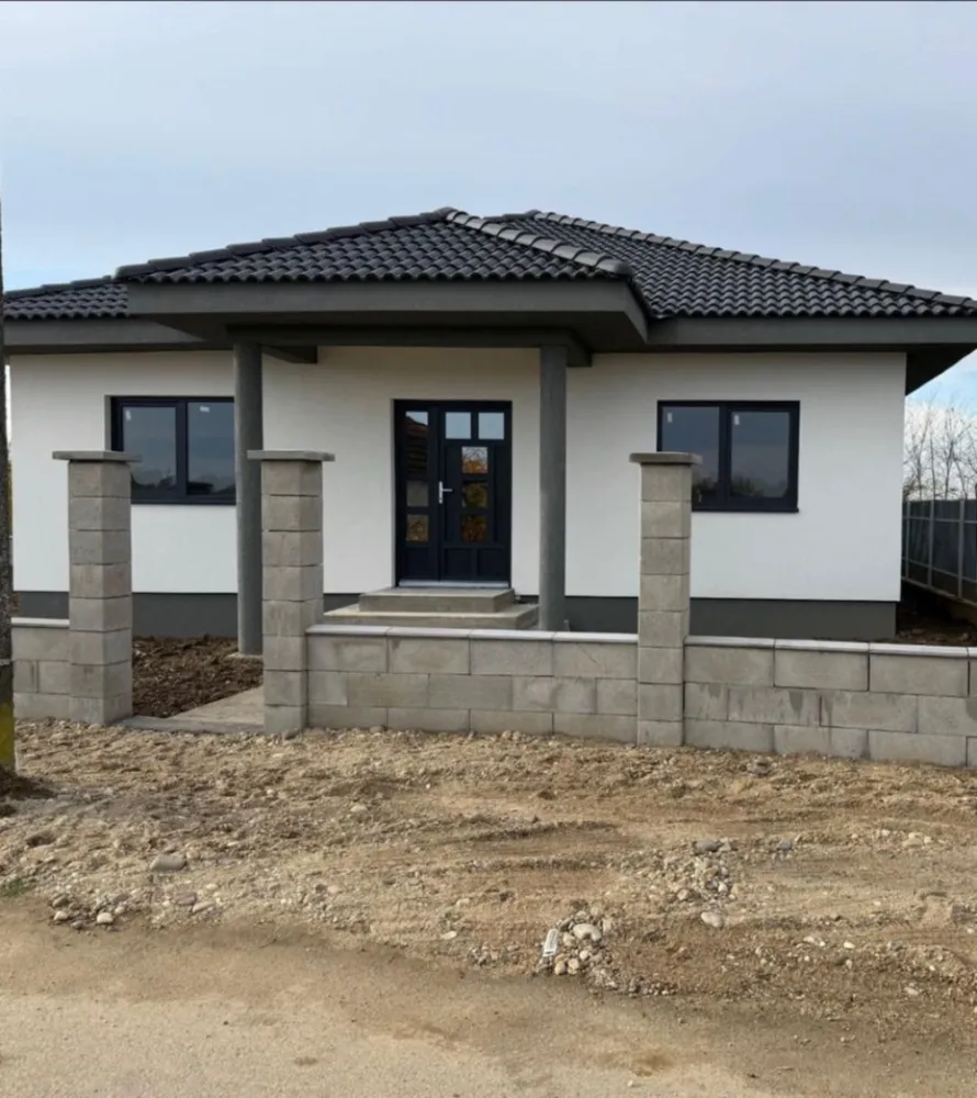 Casa de vanzare în lazuri - Casă familială nouă, modernă Lazuri (la doar 4 km de Satu Mare) Se oferă spre vânzare o casă familială nouă, modernă, amplasată într-o zonă liniștită și plăcută din Lazuri, la doar 4 km de Satu Mare. Proprietatea se întinde pe un teren de 450 m2, iar locuința are o suprafață construită de 126 m2, realizată integral din cărămidă, pe o structură solidă și durabilă, cu finisaje moderne și confort de top. Pereții sunt izolați cu polistiren de 10 cm și prevăzuți cu ferestre termopan Rehau, oferind eficiență termică și confort sporit. Acoperișul este masiv, acoperit cu țiglă de beton, iar casa dispune de încălzire în pardoseală și este racordată la apă, curent electric și canalizare. Curtea este spațioasă, curată și îngrijită, împrejmuită cu gard modern, având două intrări separate, ambele accesibile cu mașina. Compartimentare: 2 dormitoare spațioase 1 baie modernă living generos bucătărie cămară (spajz) cameră tehnică terasă mare și acoperită Actele sunt în regulă, proprietatea poate fi trecută imediat pe nume