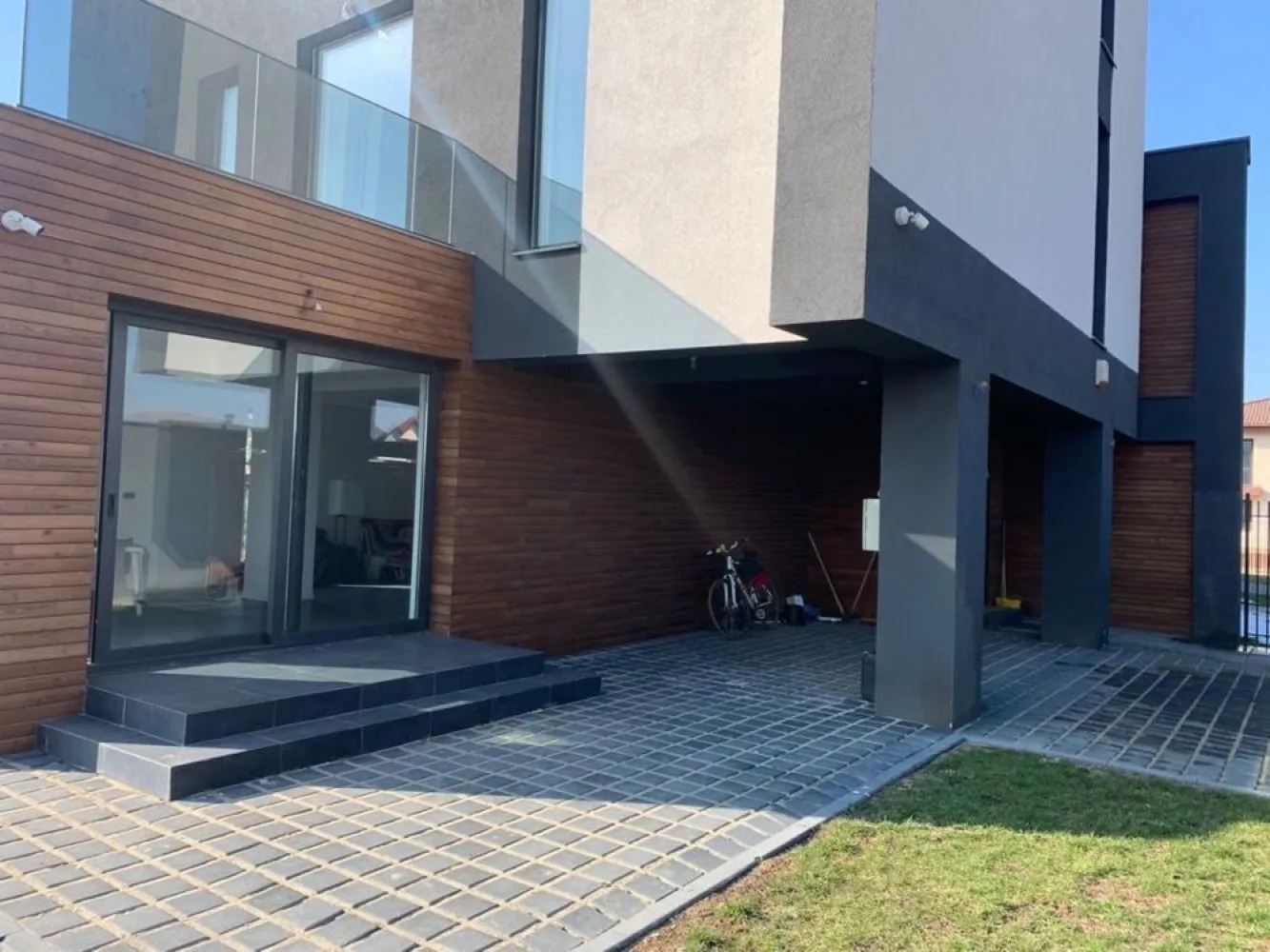 Vila 5 camere - BMS HOME CONCEPT - Strada Campul Pipera - Va prezentam spre vanzare o vila cu 5 camere ( birou, 3 dormitoare, living cu bucatarie si zona relaxare, 3 bai, 2 terase) situata in str Campul Pipera 39 Voluntari, in imediata vecinatate a Cartierului Henri Coanda, la o distanta de 3,7 km de Directia Regim permise de conducere si Inmatriculari auto. Vila este finalizata in anul 2022, este formata din P + ETJ 1 + ETJ 2, are o suprafata utila totala de 276 mp, beneficiaza de 336 MP mp teren cu o deschidere de 15ml. Curtea libera este in suprafata de 260mp, prevazuta cu pavaj , 2 locuri de parcare, alei pietonale si gazon . Suprafata utila totala este distribuita pe etaje dupa cum urmeaza : PARTER : Living + Bucatarie - 70,50 mp; Baie - 3,10 mp; Camera tehnica - 2,80 mp ETAJUL 1 Dormitor+ Dressing - 34,40 mp, Baie - 15,40 mp ,Hol+Scara - 26,68 mp , Terasa - 27,40 mp ETAJUL 2 Dormitor 1 - 14 mp; Dormitor 2 - 14 mp, Terasa - 4,50mp; Hol +Casa Scarii+Zona relaxare - 43,40mp; Baie - 10,30 mp. Camerele sunt luminoase, elegante, inalte cu finisaje de lux . La baza semnarii contractului final de vanzare cumparare vor sta urmatoarele documente : act dobandire teren, autorizatie construire , documente de calitate , carte tehnica, certificat energetic, receptie la terminarea lucrarilor, cadastru+intabulare, etc. STRUCTURA IMOBILUI este realizata din cadre de beton armat cu inchideri de zidarie porotherm de 30 cm, iar compartimentarea interioara din BCA de 15 cm. HIDROIZOLATIA este realizata atat pe terasele circulabile si necirculabile, cat si pe planseu in 5 straturi(EPS 200 DE 10CM - cu efect termoizolant) TERMOIZOLATIA - fatada ventilata in partea inferioara a imobilului este realizata cu vata minerala de 10 cm si finisata cu lambriuri din lemn termotratat. Fatada neventilata din partea superioara este realizata cu vata minerala bazaltica de 10 cm si tencuieli decorative. Intradosul planseului este termoizolat cu vata de 10 cm. TAMPLARIA EXTERIOARA s-a realizat din ferestre cu profile de aluminiu cu punte termica si placate la exterior cu sticla, feronerie GU, culoare sable noir, sticla 32 mm, 6 foi, 4 season- WEnegru-6 Float. Izolarea tamplariei a fost realizata cu membrane EPDM(membrane monostrat sintetic 100% care isi pastreaza proprietatile la -40 grade) ATIC SI GLAF METIGLA vopsite in camp electrostatic de 0,5 cm grosime, culoare sable noir. USILE DE INTERIOR sunt calitate premium tip FILOMURO cu balamale ascunse si broasca magnetica. USA DE EXTERIOR este metalica din aluminiu dur cu rupere termica si vopsita in camp electrostatic in nuanta lemnului. Usa confera o rezistenta marita la conditiile climatice severe cat si la coroziune. INSTALATIA SANITARA - la exterior : scurgeri pluviale incastrate in termosistem cu sistem de drenaj cu 3 camine colectoare. - la interior : sistem de incalzire in pardoseala tip PURMO care se alimenteaza prin agent termic (apa calda)furnizat cu ajutorul distribuitoarelor de incalzire PURMO. Exista grup de pompare PURMO, convectoare de caldura PURMO, hidrofor, statie de dedurizare si statie de filtrare a apei, centrala termica Viessman 33 kw cu boiler incorporat de 100 l, radiatoare port prosop pentru bai, electroventil de apa pentru sistem anti-inundatii. FINISAJE BAI : Izolatie tip Sika. gresie si faianta antiderapanta de calitate superioara tip Marazzi, pereti si pardoseli din microciment. Baile sunt complet echipate cu obiecte sanitare su accesorii( lavoare, baterii, cabine dus si cazi freestanding din compozit), vas de toaleta suspendat si bideu cu rezervor incastrat tip TECE, blaturi din lemn masiv. Baile sunt echipate cu prize etanse cu contact de protectie si instalatie de iluminat preinstalata pentru corpurile de iluminat. FINISAJE INTERIOARE : Lavabil interior de calitate superioara, aer conditionat cu traseu frigorific din cupru, izolatie fonica cu polistiren de 5 cm, trepte metalice suspendate finisate cu lemn termotratat, parchet tip dusumea, pardoseli microciment living, bucatarie, circuit electric pentru insula din bucatarie, traseu evacuare hota, termostat caldura pentru fiecare camera. FINISAJE TERASA : glaf piatra 2 cm cu cant tip WASSERNAS, pardoseala DECK din lemn termotratat, balustrada aluminiu cu sticla 8.8.3 laminat, securizat, float plus gray, , priza exterioara. INSTALATIE ELECTRICA(220V/380V- CURENT TRIFAZIC) : Intrerupatoare touch tip LIVOLO, preechipare statie exterioara incarcare auto, sistem iluminat ambiental exterior, prize exterioare, senzori anti - inundatie si anti- incendiu.Sistemul BMS implementat permite sa controlam si sa monitorizam functiile casei. Zona permite acces rapid catre Parcul Herastrau cat si in toate celelalte puncte de interes ale Capitalei. Strazile de acces catre vila sunt largi, regimul de inaltime al zonei este de P+ 2, nu se creeaza puncte de aglomerare catre Bulevardul principal. Zona este ferita de zgomotul intens stradal cat si de formarea intensa a poluarii.