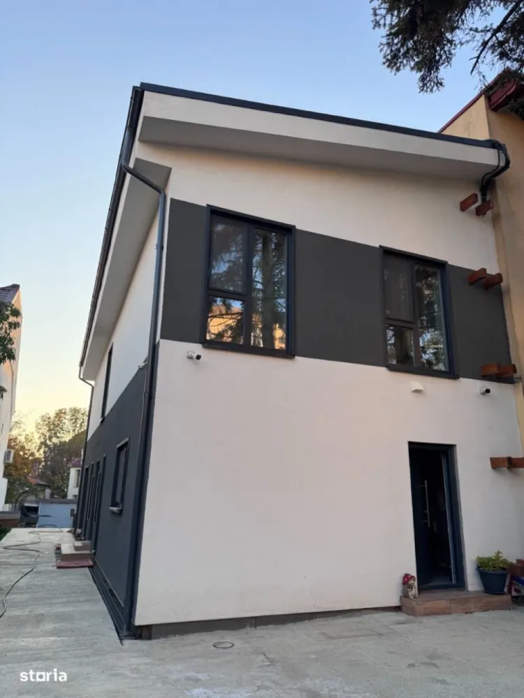 Vila verde cartier Baneasa - Casa in cartier Baneasa, conceputa pentru a deveni independenta energetic, cu aproape zero costuri de întreținere.  Finisajele premium și elementele de lux, designul modern și tehnologiile de ultimă generație, fac din aceasta o alegere ideala. Casa are dotări specifice locuințelor pasive: circuit încălzire / racire prin pardoseală conectat la pompa de căldură aer-apă, sistem centralizat de ventilație HVAC cu recuperare de căldură (momentan fara unitatea centrala), sistem SMART de climatizare si panouri fotovoltaice.     - casa pe structura metalica usoara (an finalizare 2024) - suprafata utila casa: 189mp - suprafața amprenta la sol: 95mp - suprafața totala teren:  472mp - 3 dormitoare - 3 bai ( 2 dotate cu dus walk-in și 1 cu cadă) - living open space  - bucatarie inchisa (16mp) - camera tehnica - spații de depozitare - terasa acoperita - 2 locuri de parcare (posibilitate de construcție garaj -  se poate oferi proiect + execuție)- magazie - poarta auto tip rulou automata  - pompa de caldura aer-apa Daikin - incalzire si racire in pardoseala Rehau (sistem NEA SMART climatizare)- panouri fotovoltaice 19.5 KW  (contract PPC prosumator)- curent trifazat- sistem HVAC montat la interior (fără unitatea centrala în camera tehnica)- sistem de camere supraveghere - ferestre: PVC SALAMANDER, seria bluEvolution 92 (baghete warm și precadre pentru prevenirea transferului termic)- finisaje premium: lavabila interior STO / riflaj / tencuiala decorativa interior - gresie / faianta premium (dimensiuni placi 60 x 120)- parchet premium - mobila bucatarie premium - mobila premium pe comanda (canapea / dressing + pat dormitor matrimonial)- dotari bai premium (masina de spalat haine si uscator haine)- electrocasnice - bucatarie utilata complet - dotari living (TV Samsung OLED + Soundbar JBL) - izolatie exterior polistiren grafitat expandat 15cm - izolatie interior celuloza 14cm (pereti si tavane)- folie bariera de vapori (toti peretii interiori)- rigips ignifug + rigips antiumezeala bai- tencuiala decorativa STO - acoperiș tabla click Wetterbest - usa metalica izolata cu vata bazaltica