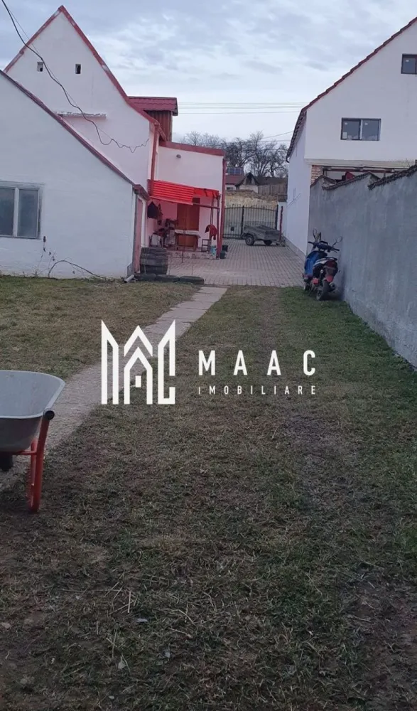 Casă Săsească Hosman | 3 camere | Teren 1076 mp - Vă prezentăm o casă fermecătoare, ideală pentru cei care caută liniștea și frumusețea vieții la țară, situată la doar 25 km de Sibiu. Această proprietate renovată recent oferă toate condițiile moderne, păstrând în același timp farmecul rustic. Caracteristici principale: Suprafață teren: 1076 mp, împărțită inteligent între curte, grădină și zone de utilitate. Compartimentare: 3 camere spațioase și luminoase. 1 bucătărie practică și bine dotată. 2 băi moderne, ideale pentru confortul familiei. Pivniță uscată, potrivită pentru depozitare. Dotări și facilități: Locuința a fost renovata recent, oferind un mediu confortabil și primitor. Apă, gaz, curent electric, fosa septica. Încălzire eficientă: Centrală termică, calorifere pe hol, sobe de teracota( necesita racordate la gaz). Anexe și exterior: Grajd și șură, cu multiple posibilități de utilizare. Garaj si spațiu in curte pentru mașini. Curte pavată, perfectă pentru relaxare și activități în aer liber. Grădină generoasa pentru cei care iubesc grădinăritul. Această proprietate este ideală pentru cei care doresc să se bucure de spațiu generos, natură și intimitate. 📞 Contactați MAAC Imobiliare pentru mai multe informații sau pentru a programa o vizionare, menționează CP2778739 ! }}